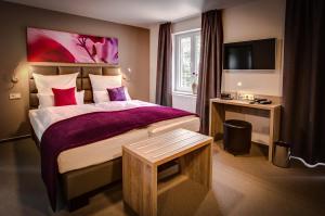 una camera d'albergo con un grande letto e una scrivania di Weserhotel Schwager a Holzminden