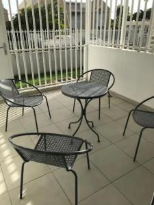 a group of chairs and tables on a balcony at Meublé de standing au coeur des commodités in Schœlcher