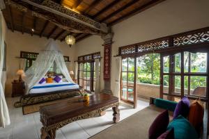 a bedroom with a bed with a canopy at Alam Jiwa Ubud in Ubud