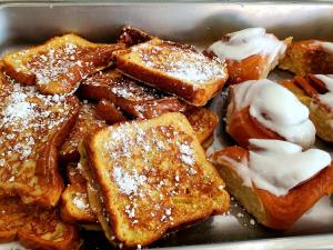 a tray of french toast with powdered sugar on it at Vero Beach Inn & Suites Vero Beach I-95 in Vero Beach