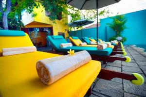 a row of yellow chairs and couches on a patio at Dickman Resort "The Boutique Hotel" in Negombo