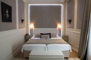 a bedroom with a large bed with a white headboard at Best Western Premier Grand Monarque Hotel & Spa in Chartres