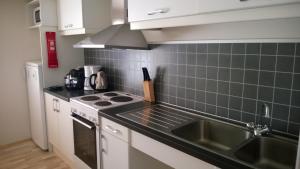 a kitchen with a sink and a stove at Comfortable Bungalow in Ísafjörður