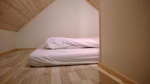 een slaapkamer met een bed met een witte deken bij Comfortable Bungalow in Ísafjörður