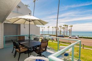 balcón con mesa, sillas y vistas al océano en Ocean View with Large Balcony, Air Conditioned, en Oceanside