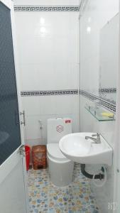 a bathroom with a white toilet and a sink at Homestay view đồi Hòn Sơn in Lai Sơn +12 photos
