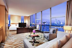 南昌市にあるHoliday Inn Nanchang Riverside, an IHG Hotelのベッドと大きな窓が備わるホテルルームです。