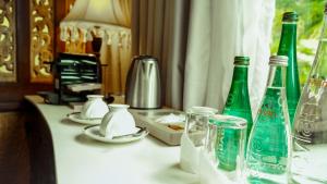 a table with green bottles and glasses on it at Rancho Bernardo Luxury Villas and Resort in Bagac