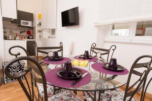 ローマにあるBaccina Innの紫色のテーブルと椅子が備わるダイニングルーム