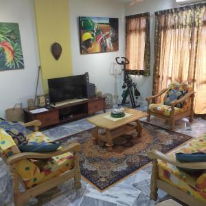 ein Wohnzimmer mit 2 Stühlen und einem Tisch in der Unterkunft Relaxing Retreats at Cocobay Apartments in Port Dickson