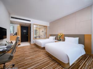 um quarto de hotel com duas camas, uma secretária e um computador em Holiday Inn Nanchang Riverside, an IHG Hotel em Nanchang