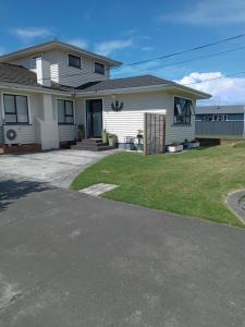 a white house with a yard and a driveway at Thistle B&B in Napier