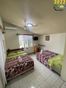 a bedroom with two beds and a ceiling fan at Sun Breeze Hotel in El Remate