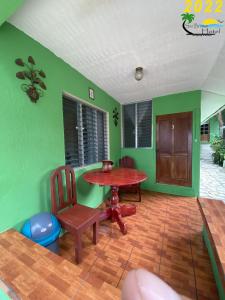 a dining room with green walls and a table and chairs at Sun Breeze Hotel in El Remate