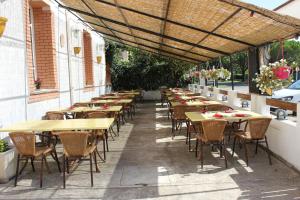 una fila di tavoli e sedie su un patio di Hotel Restaurant La Camargue a Salin-de-Giraud