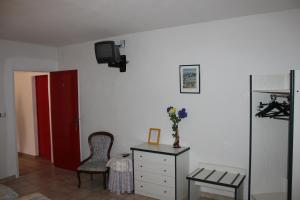 Cette chambre comprend une commode et une télévision murale. dans l'établissement Hotel Restaurant La Camargue, à Salin-de-Giraud