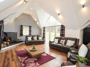 a living room with leather furniture and a fireplace at Craigfa Cottage in Bangor