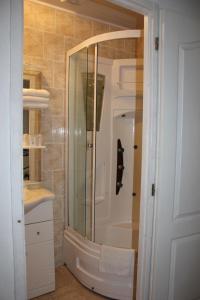 bagno con doccia, lavandino e specchio di Hotel Restaurant La Camargue a Salin-de-Giraud