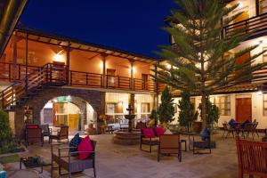 ein Innenhof bei Nacht mit Stühlen und einer Palme in der Unterkunft Union Hotel Cusco in Cusco