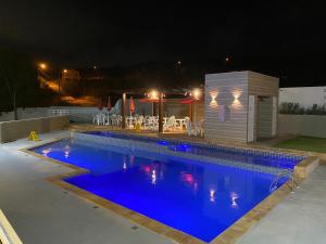 a swimming pool with blue water at night at Gravata em Condomínio LINDO - Casa com 200m com 4 QTS e 5 WC in Gravatá