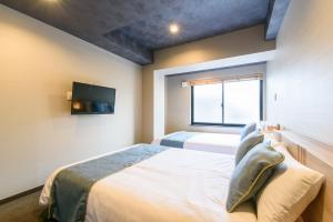 Cama ou camas em um quarto em JP INN Kyoto Ekimae Mongakucho