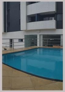 a large blue swimming pool in front of a building at Flat Biarritz - Ao lado da Litoranea - Ferreira Hospedagens in São Luís