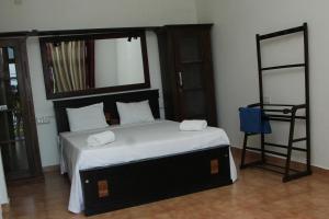 a bedroom with a large bed and a mirror at Perla Fisherman Bay in Weligama