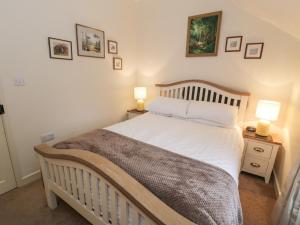 a bedroom with a white bed with two night stands at Bwthyn Afon River Cottage in Blaenau-Ffestiniog