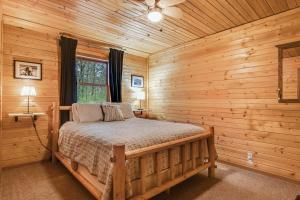 um quarto com uma cama num chalé de madeira em Luxe Lodge & Cabins III em New Lisbon