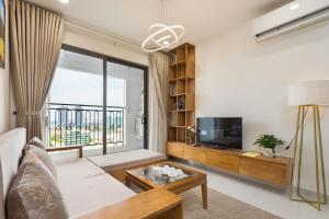 The Saigon Suite, The Luxury 2 bedrooms with bathtub for over 30 nights في مدينة هوشي منه: غرفة معيشة بها أريكة وتلفزيون ونافذة