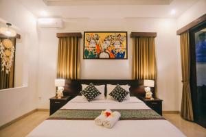 a bedroom with a bed with two pillows at Puri Arta Villa in Ubud
