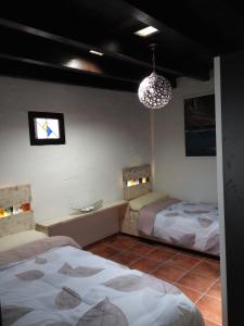 1 Schlafzimmer mit 2 Betten und einem Kronleuchter in der Unterkunft ALOELUXVILLA COM (II) in Tías
