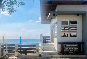 ein weißes Haus mit dem Ozean im Hintergrund in der Unterkunft E. Moreno Recreation Beach Resort Ilocos Sur in Candon