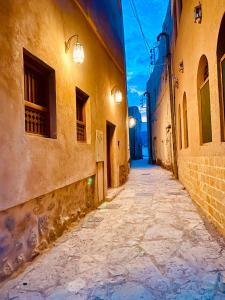 eine Gasse in einer Altstadt nachts in der Unterkunft Jawharat Alaqar Inn نزل جوهرة العقر in Nizwa