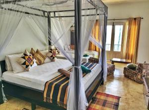 a bedroom with a canopy bed and a living room at Old Frankland Kandy Luxury Boutique Hotel in Kandy