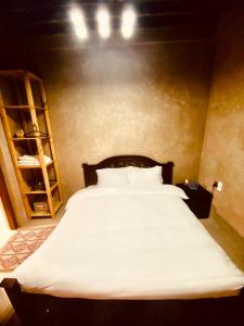 ein Schlafzimmer mit einem großen weißen Bett in einem Zimmer in der Unterkunft Jawharat Alaqar Inn نزل جوهرة العقر in Nizwa