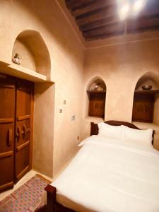 سرير أو أسرّة في غرفة في Jawharat Alaqar Inn نزل جوهرة العقر