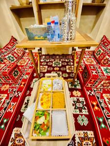 a table with several plates of food on a rug at Jawharat Alaqar Inn نزل جوهرة العقر in Nizwa