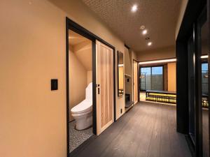 a bathroom with a toilet and a door to a room at Rinn Kiyomizu Gojo Machiya in Kyoto