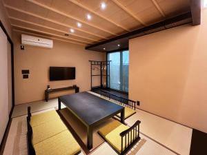 a room with a table and a flat screen tv at Rinn Kiyomizu Gojo Machiya in Kyoto