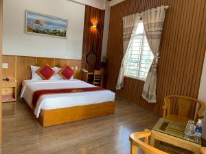 Schlafzimmer mit einem Bett, einem Tisch und einem Fenster in der Unterkunft King Hotel in Quy Nhon
