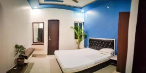 a room with a bed and a blue wall at The White Canyon Hotel in Varanasi