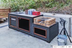 una estufa negra con fregadero y cajas. en Little Hermit by SANA en Tateyama