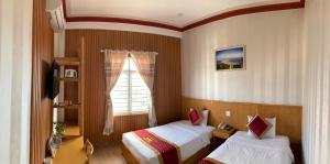 1 Schlafzimmer mit 2 Betten und einem Fenster in der Unterkunft King Hotel in Quy Nhon