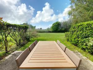 een houten bank in een park met een veld bij Residence Le Bocage - Piscine chauffee in Talmont