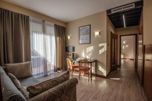 - un salon avec un canapé et une table dans l'établissement Hotel Petra, à La Romanina