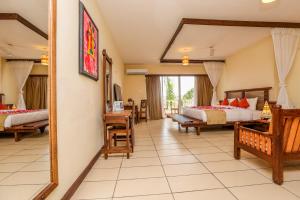 Habitación de hotel con 2 camas y espejo en CityBlue Creekside Hotel & Suites, en Mombasa