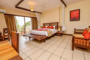 um quarto de hotel com uma cama e uma varanda em CityBlue Creekside Hotel & Suites em Mombasa