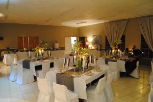 a banquet hall with white tables and white chairs at Eagles Nest Chalets in Hazyview