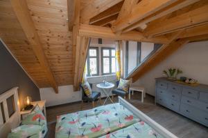a attic room with a bed and a table at Gästehaus am Stadttor in Naumburg
